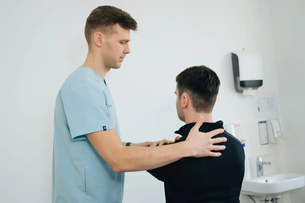 A physiotherapist helping a patient stretch her shoulder